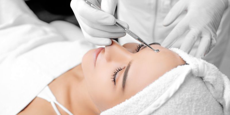 A woman is happy while undergoing a deep pore cleansing facial.